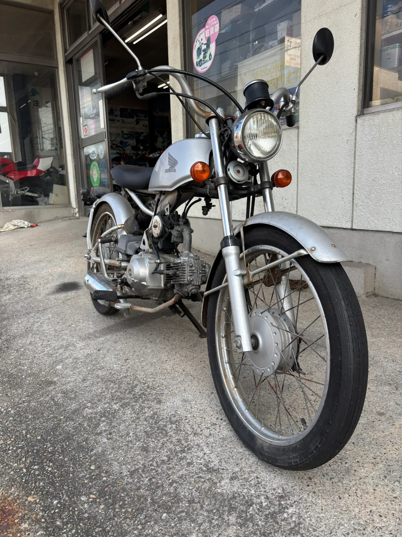 店先に置かれたシルバーの小型バイクの正面