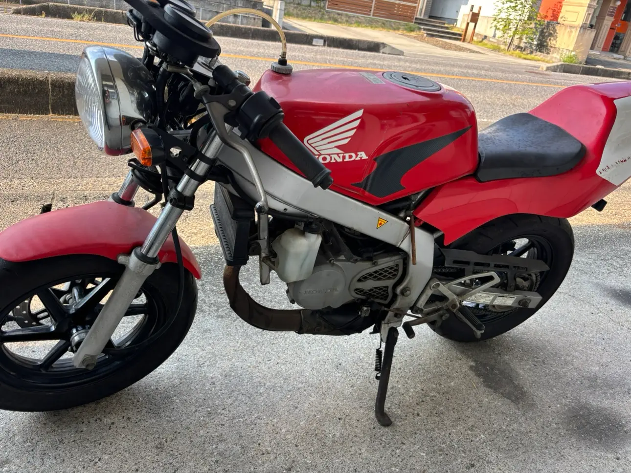 赤いNSR50の側面。タンクにホンダの翼マーク、テールにPRO-ARMの文字がある
