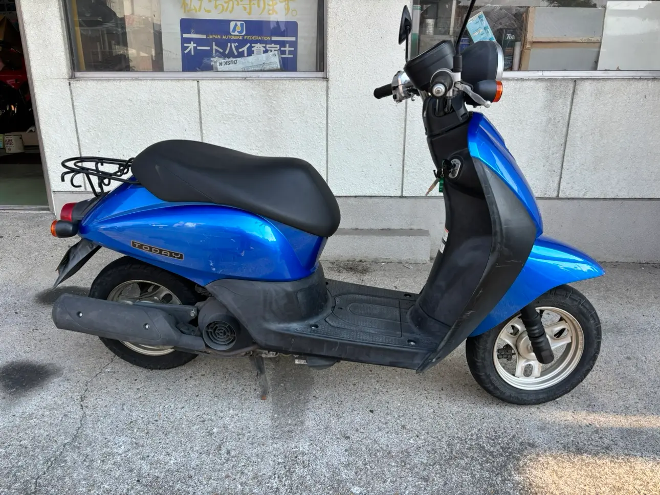 青いホンダ Todayの側面。ボディにTODAYの文字とリアキャリアがある