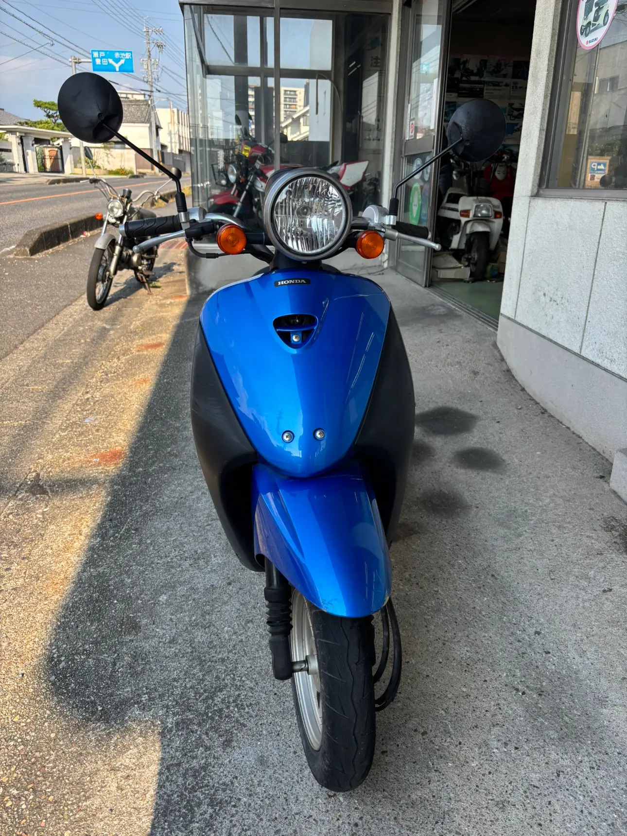 青いホンダ Todayの正面。丸型ヘッドライトと左右のミラー